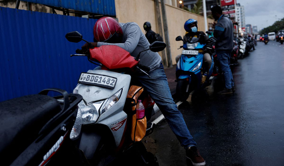 A man waits in a queue to buy petrol